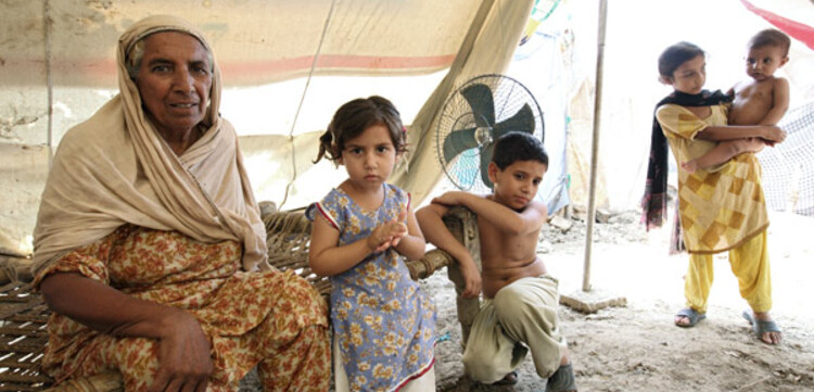 Flut Pakistan: Alte Frau mit Kindern in einem Zelt