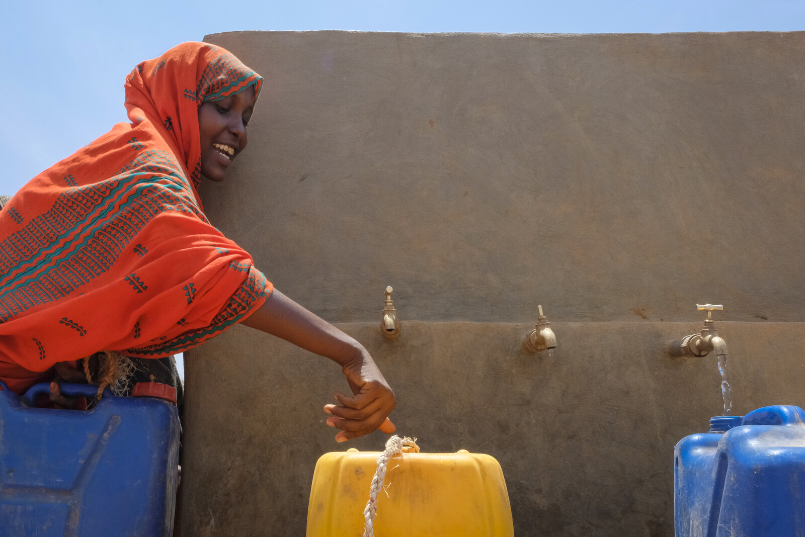 Eine Frau in Äthiopien füllt sauberes Trinkwasser in Kanister