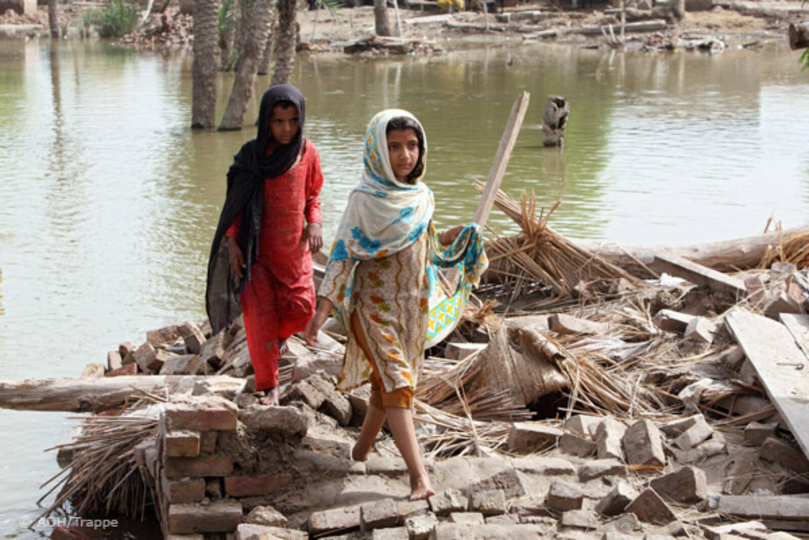 Flut Pakistan: Mädchen laufen über Trümmer