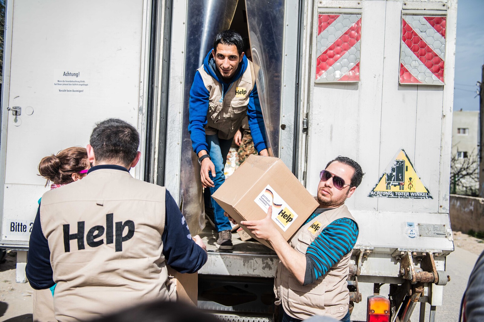 Mitarbeiter einer Hilfsorganisation entladen Versorgungspakete für syrische Flüchtlinge
