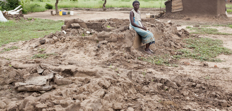Eine Frau in Malawi vor ihrem durch Zyklon Idai zerstörten Haus 