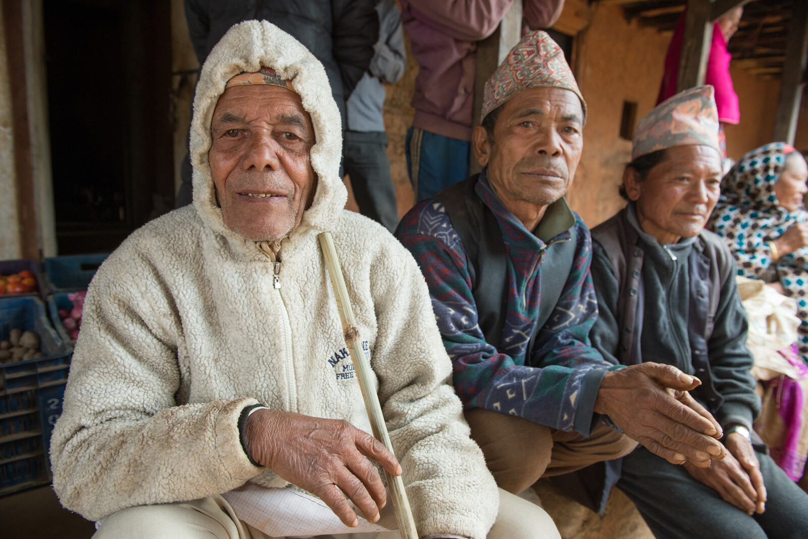 Eine Gruppe älterer Menschen sitzt zusammen nach dem Erdbeben in Nepal.