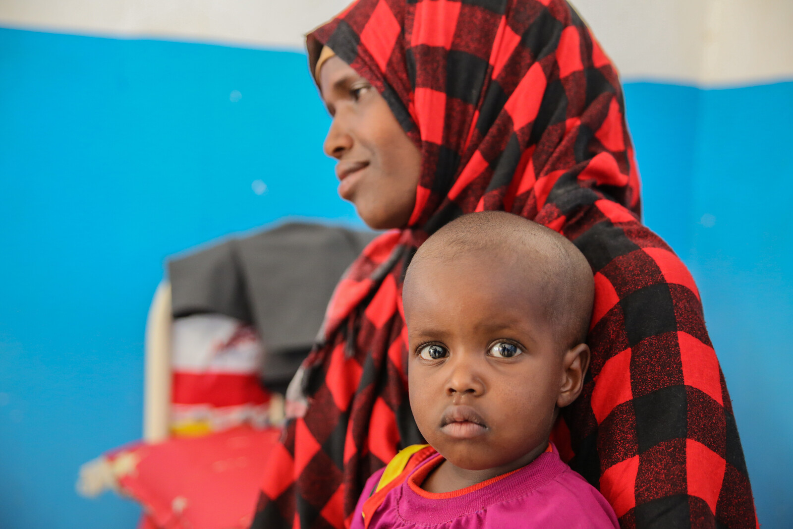 Eine Frau in Somalia wartet in einem Krankenhaus in Somalia mit ihrem Kind auf einen Arzt.