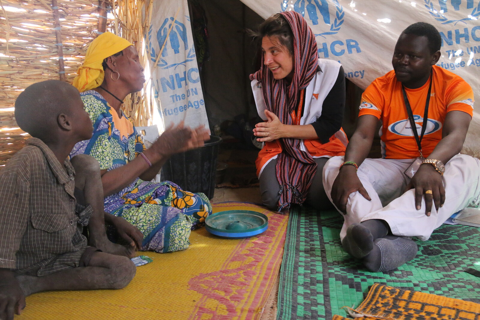Die Mitarbeiterin einer Bündnisorganisation spricht mit einer geflüchteten Familie aus dem Niger.