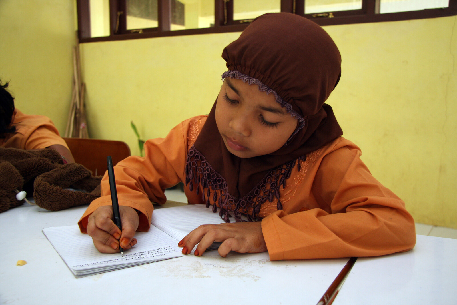 Fünf Jahre nach dem Tsunami in Indonesien sind Schulen wieder aufgebaut. Ein Mädchen lernt schreiben und lesen.