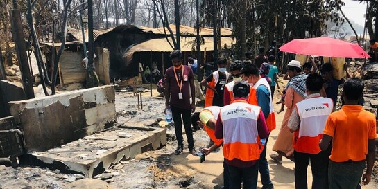 Helfer:innen begutachten Schäden nach Brand in Flüchtlingslager der Rohingya.