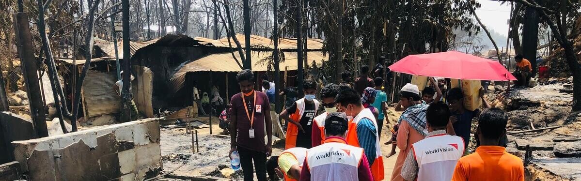 Helfer:innen begutachten Schäden nach Brand in Flüchtlingslager der Rohingya.