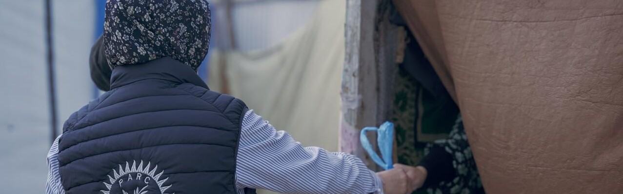 Eine Helferin reicht im Gazastreifen eine Tüte mit Essen in eine Notunterkunft Eine Helferin reicht im Gazastreifen eine Tüte mit Essen in eine Notunterkunft