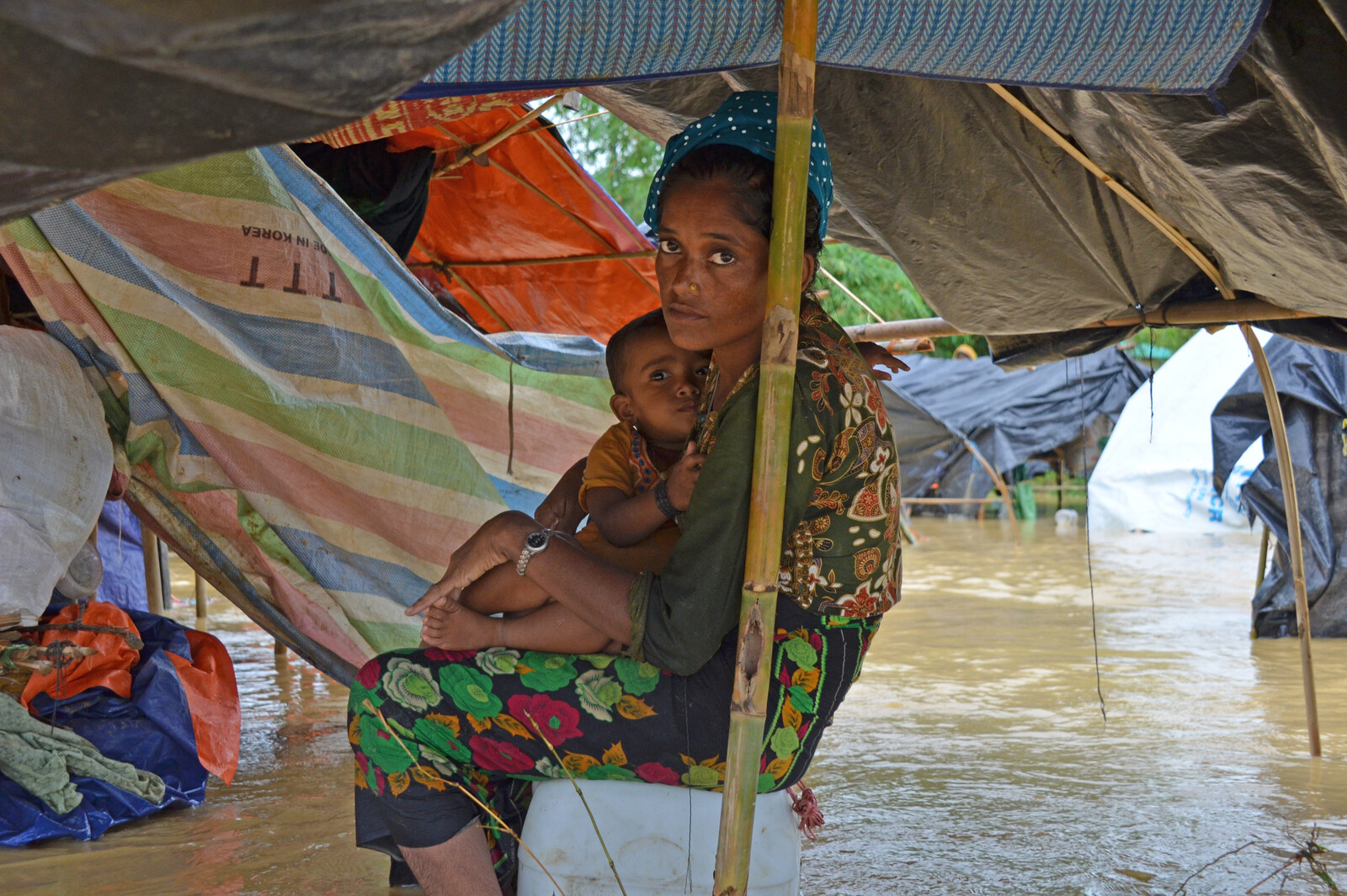 Frau mit Kind in einem der überschwemmten Flüchtlingslager in Bangladesch