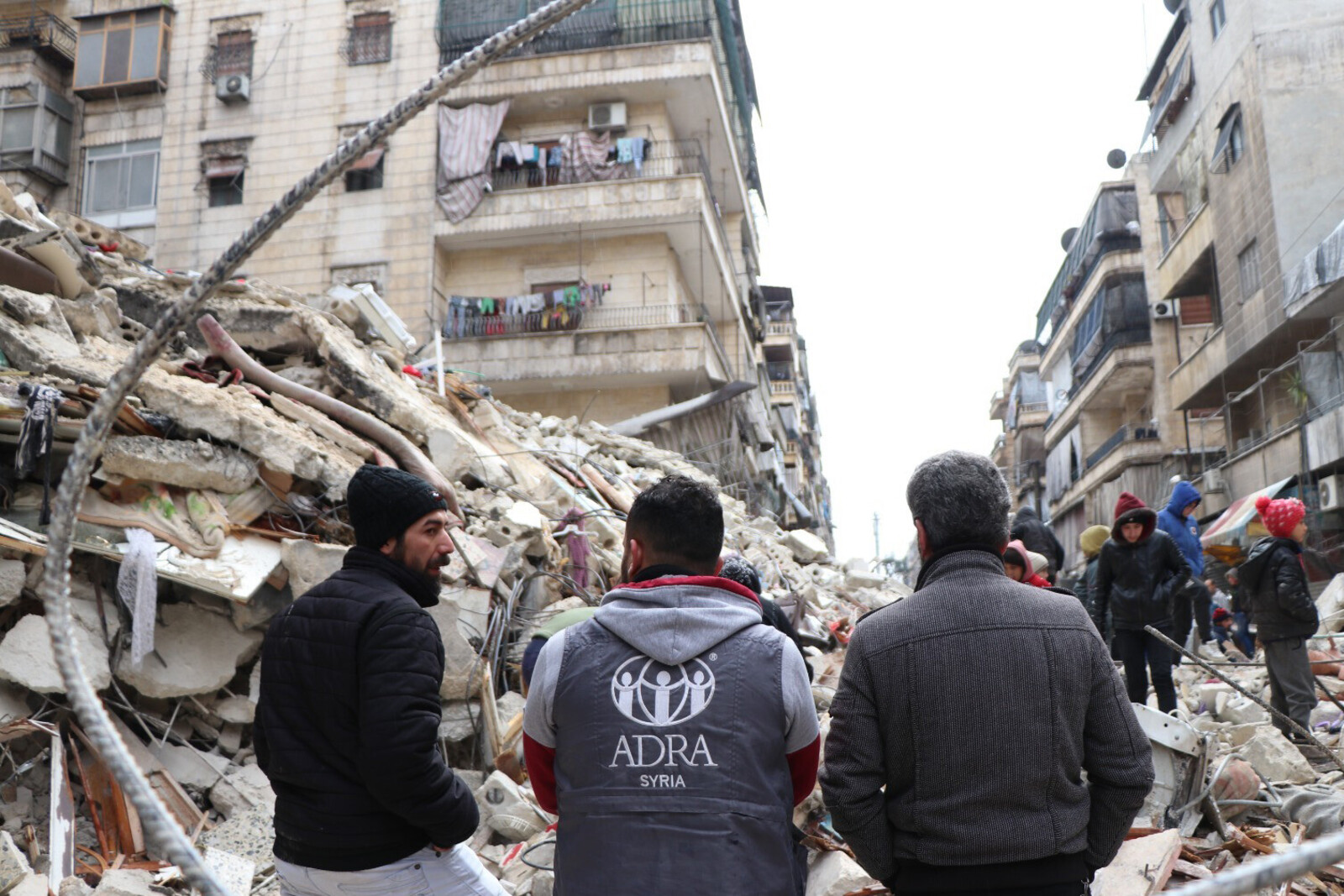 Helfer von ADRA vor vom Erdbeben zerstörten Häuser in Syrien 
