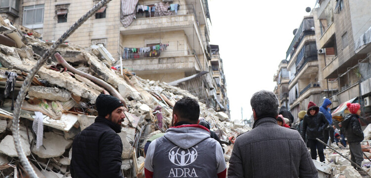 Helfer von ADRA vor vom Erdbeben zerstörten Häuser in Syrien Helfer von ADRA vor vom Erdbeben zerstörten Häuser in Syrien