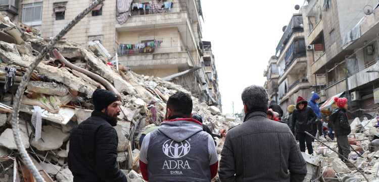 Helfer von ADRA vor vom Erdbeben zerstörten Häuser in Syrien Helfer von ADRA vor vom Erdbeben zerstörten Häuser in Syrien
