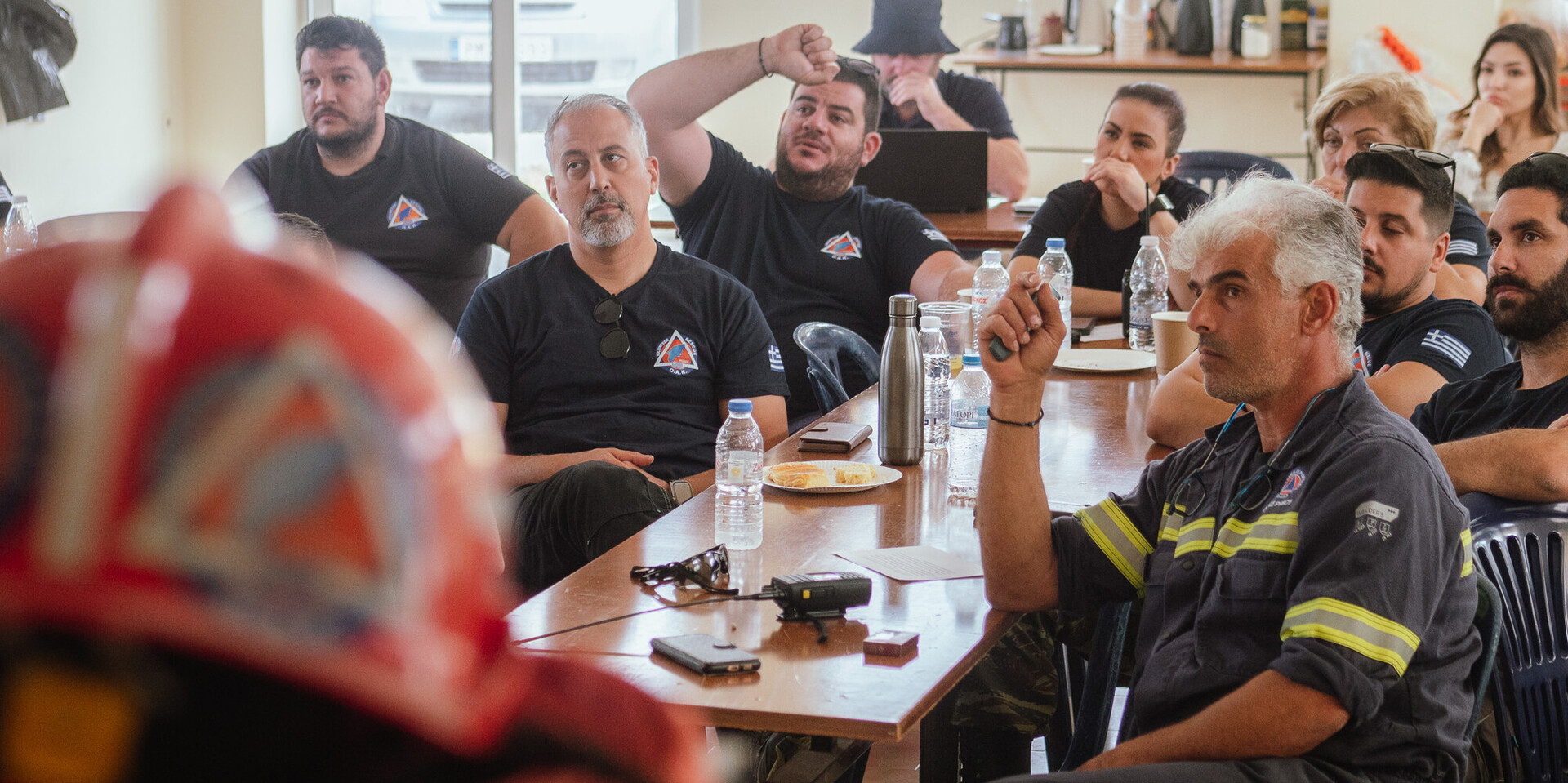In Griechenland sitzen mehrere Männer bei einem Workshop zum Thema Brandschutz und Katastrophenvorsorge zusammen. In Griechenland sitzen mehrere Männer bei einem Workshop zum Thema Brandschutz und Katastrophenvorsorge zusammen.
