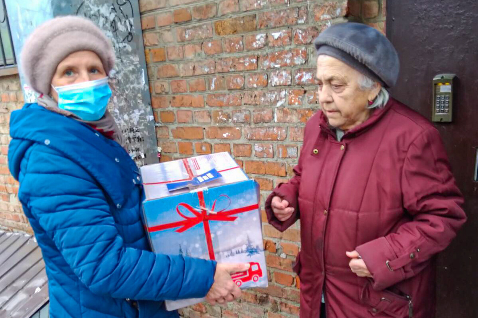 Ältere Frau aus der Ukraine erhält ein Hilfspaket der Malteser