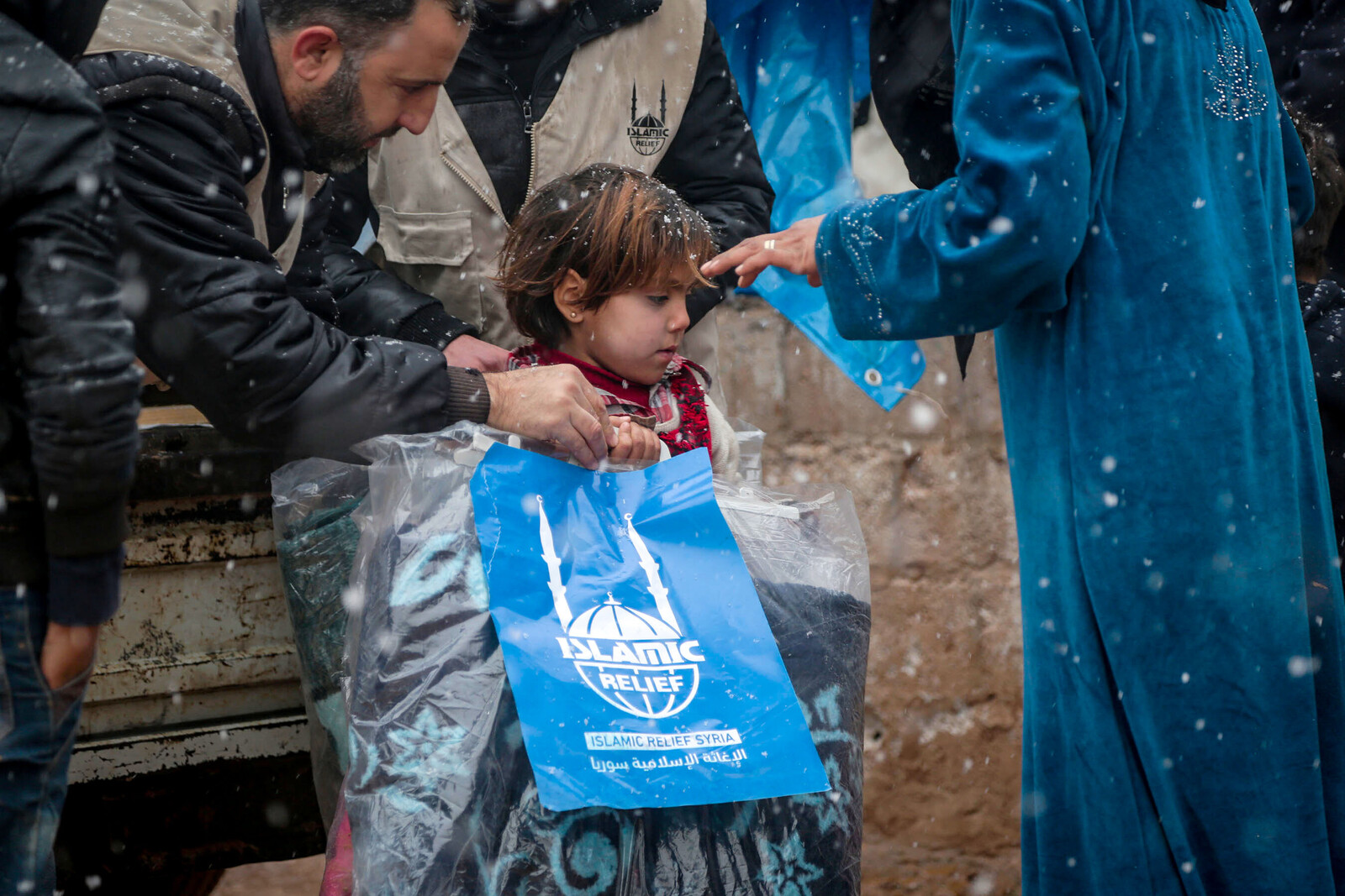 An Kinder werden Decken in Aleppo verteilt