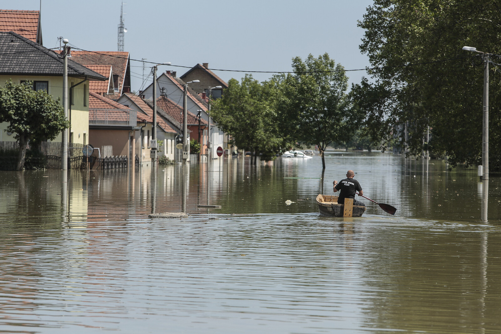 Mann im Boot auf überschwemmter Straße