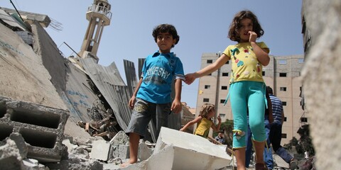 Ein Junge und ein Mädchen steigen in Gaza über Trümmer
