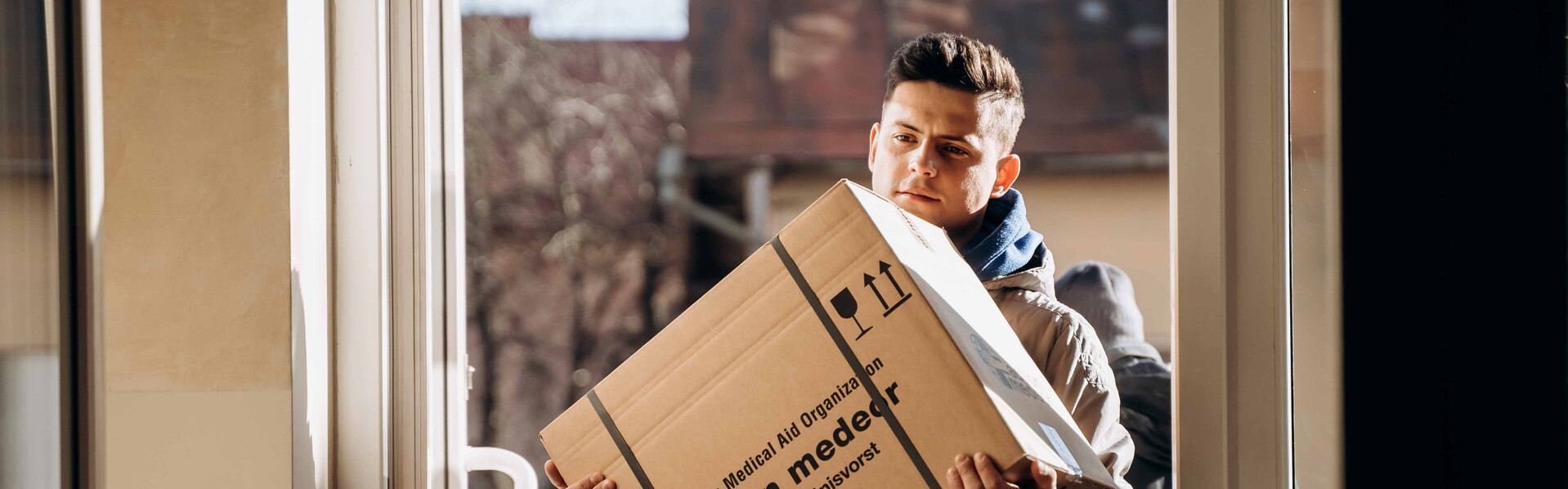 Ein Helfer trägt ein Paket mit medizinischen Hilfsgütern