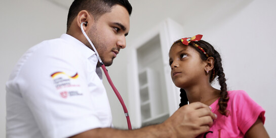Ein Arzt in Kolumbien hört ein Mädchen mit einem Stethoskop ab