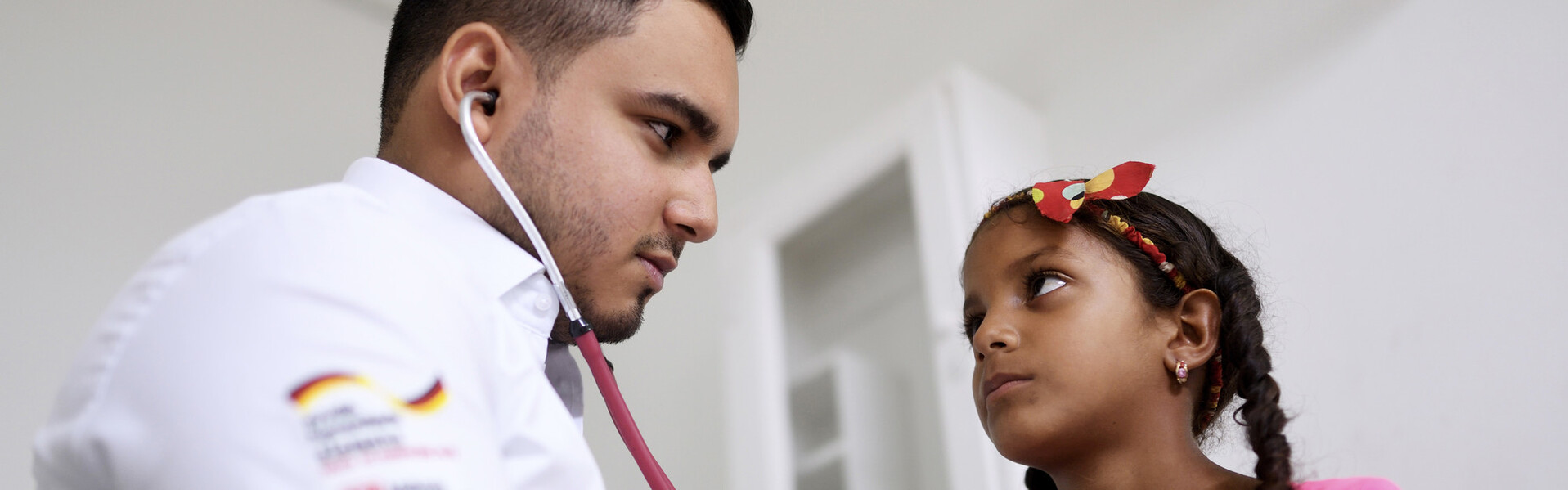 Ein Arzt in Kolumbien hört ein Mädchen mit einem Stethoskop ab