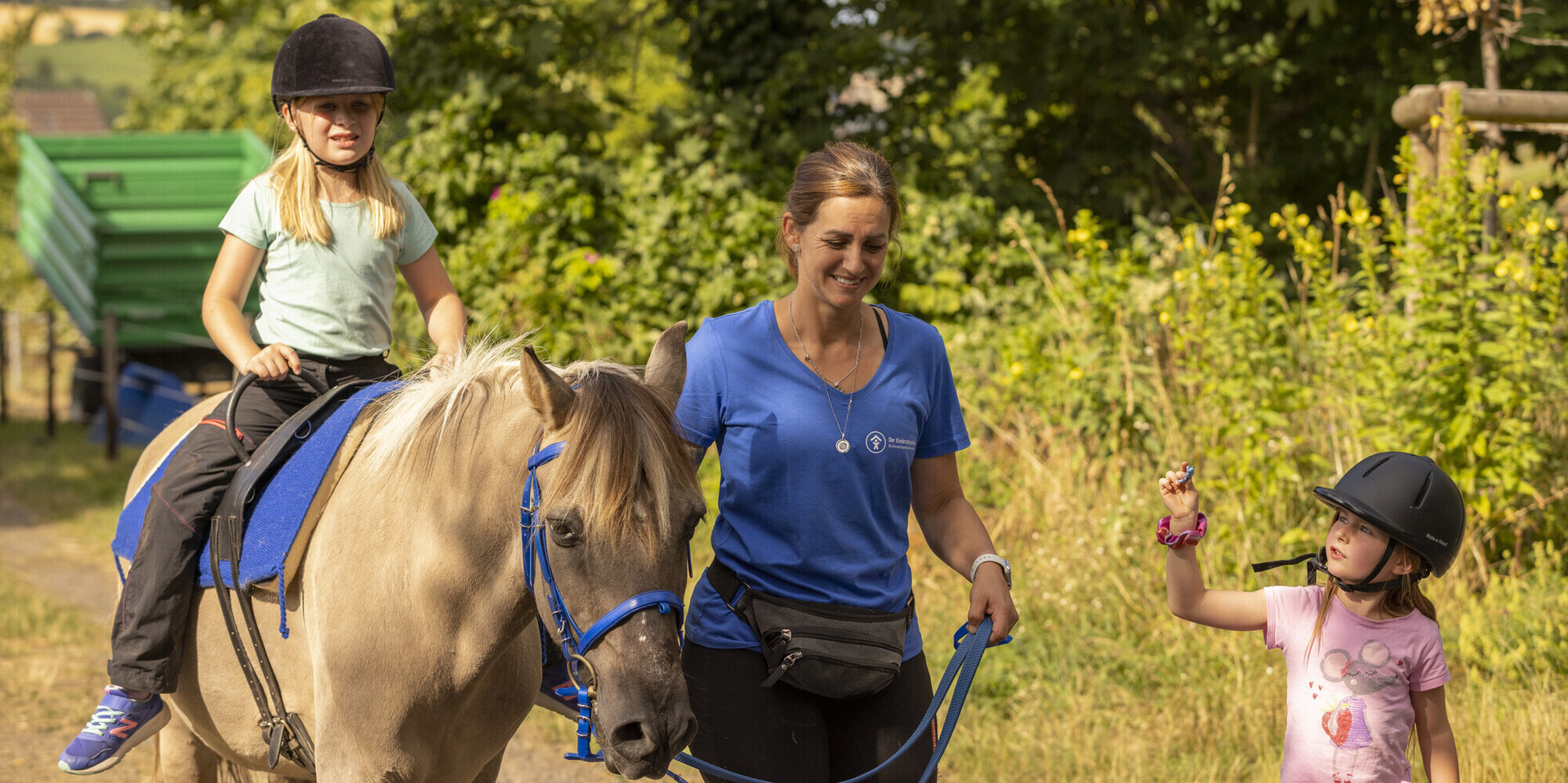 Ein Mädchen reitet auf Pony Merlin