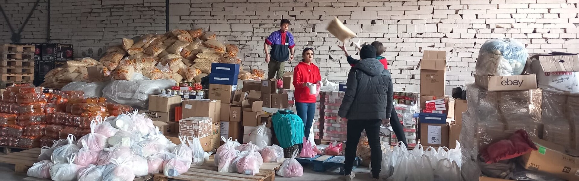 Helfer:innen arbeiten in einem Sammelplatz für Lebensmittel für Menschen in der Ukraine