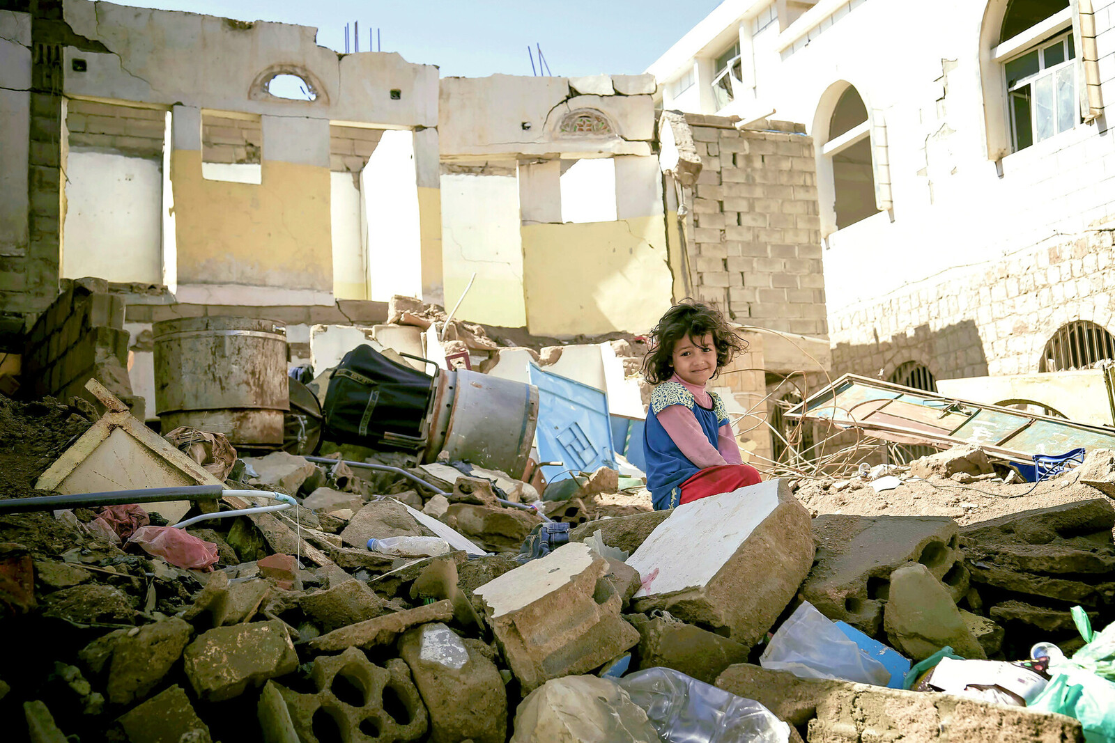 Ein Mädchen im Jemen sitzt auf Trümmern