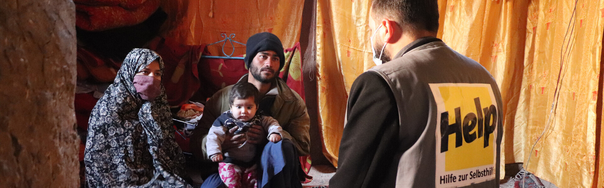 Eine afghanische Familie spricht mit einem Helfer der Organisation Help – Hilfe zur Selbsthilfe Eine afghanische Familie spricht mit einem Helfer der Organisation Help – Hilfe zur Selbsthilfe