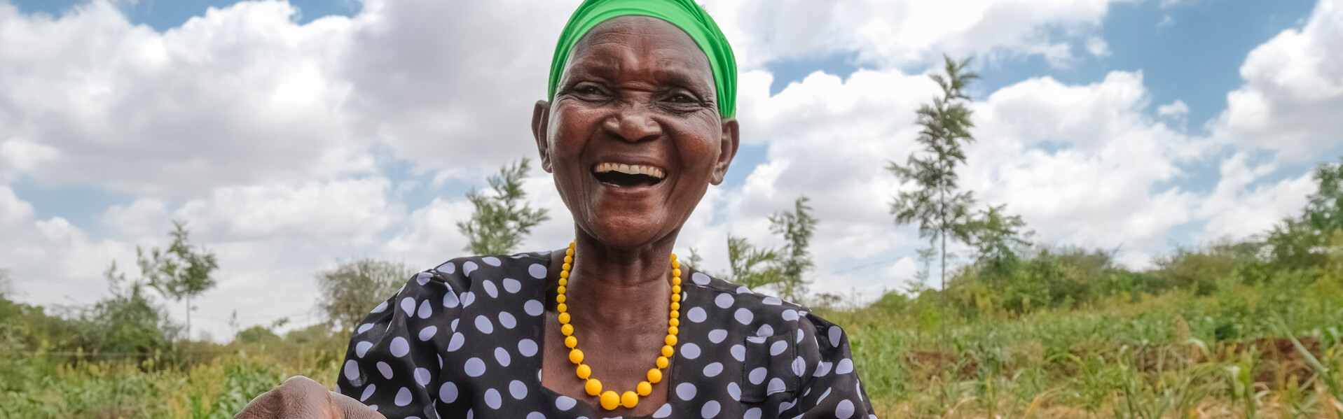 Eine Frau in Kenia trägt einen Korb mit Bohnen