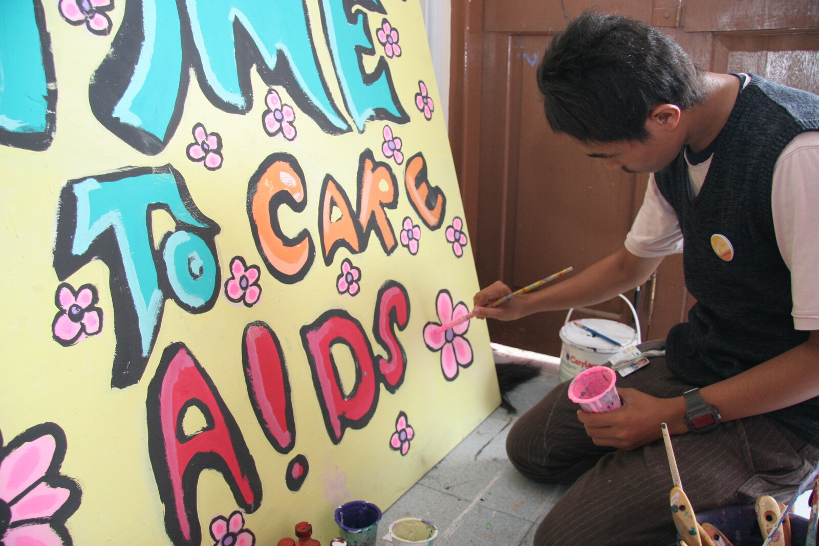 HIV und AIDS sind ein großes Problem, speziell in Afrika und Asien. Ein Mann malt Plakate für eine Informationsveranstaltung.