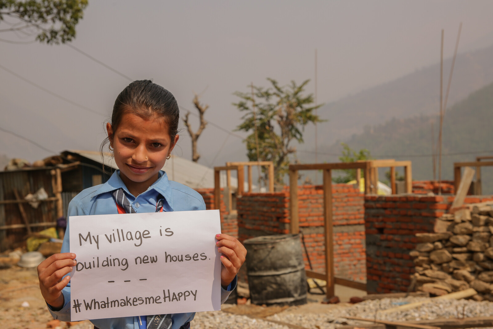 Ein Mädchen in Nepal freut sich, wenn ihr Haus wieder aufgebaut ist.