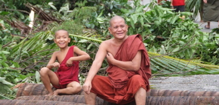 Zyklon Myanmar: 2 Mönche sitzen auf Baumstämmen