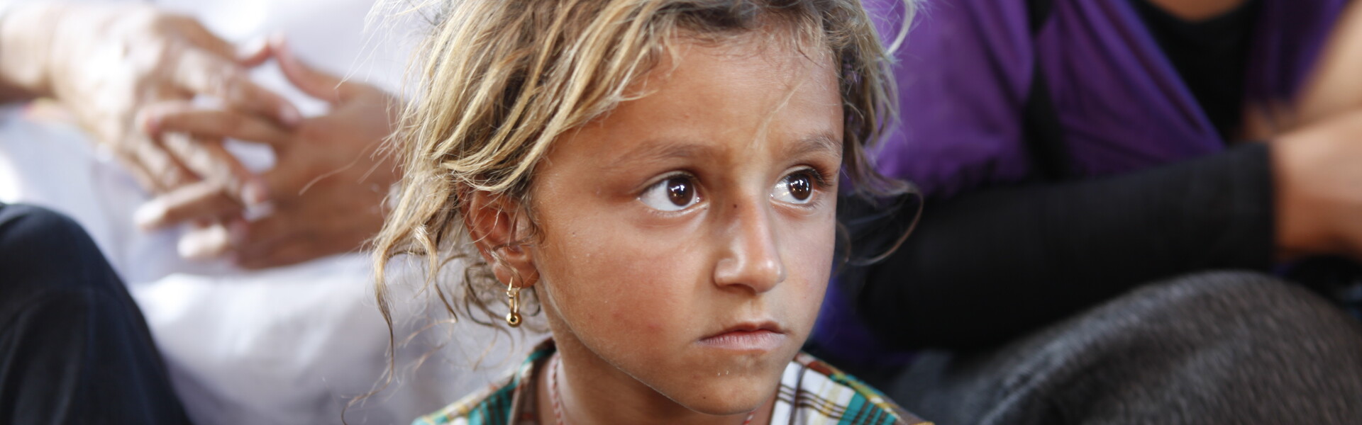 Ein junges Mädchen, das vor den Kämpfen im Irak floh, sitzt in einem Zelt.