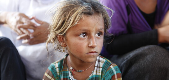 Ein junges Mädchen, das vor den Kämpfen im Irak floh, sitzt in einem Zelt.