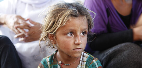 Ein junges Mädchen, das vor den Kämpfen im Irak floh, sitzt in einem Zelt.