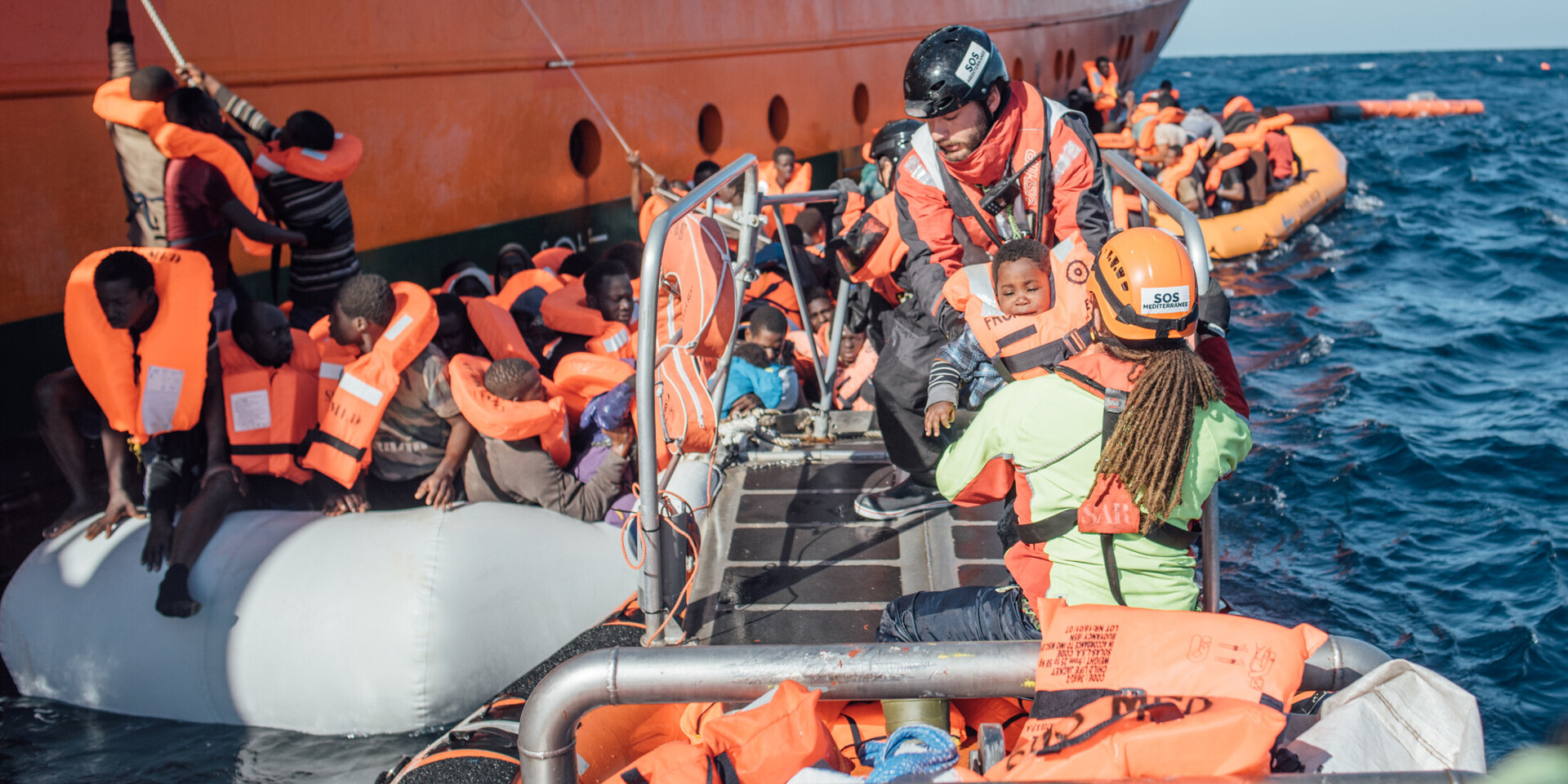 Helferinnen und Helfer der Organisation SOS Humanity bei einem Rettungseinsatz auf hoher See