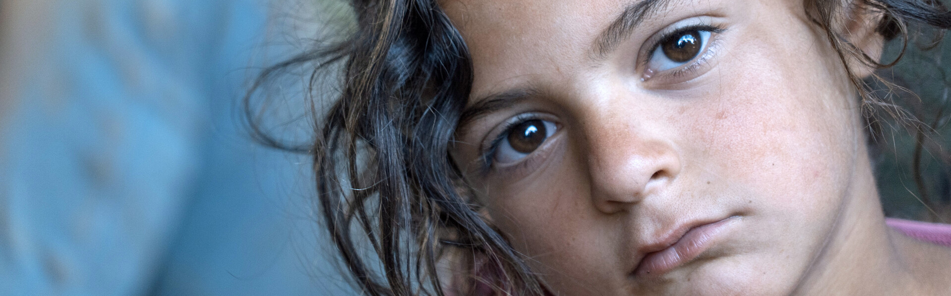 Ein Mädchen in einem Flüchtlingslager in Syrien schaut traurig in die Kamera