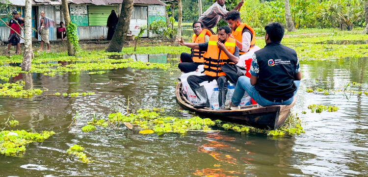 Männer in einem Boot liefern Lebensmittel und Wasser an überschwemmte Haushalte in Bangladesch Männer in einem Boot liefern Lebensmittel und Wasser an überschwemmte Haushalte in Bangladesch
