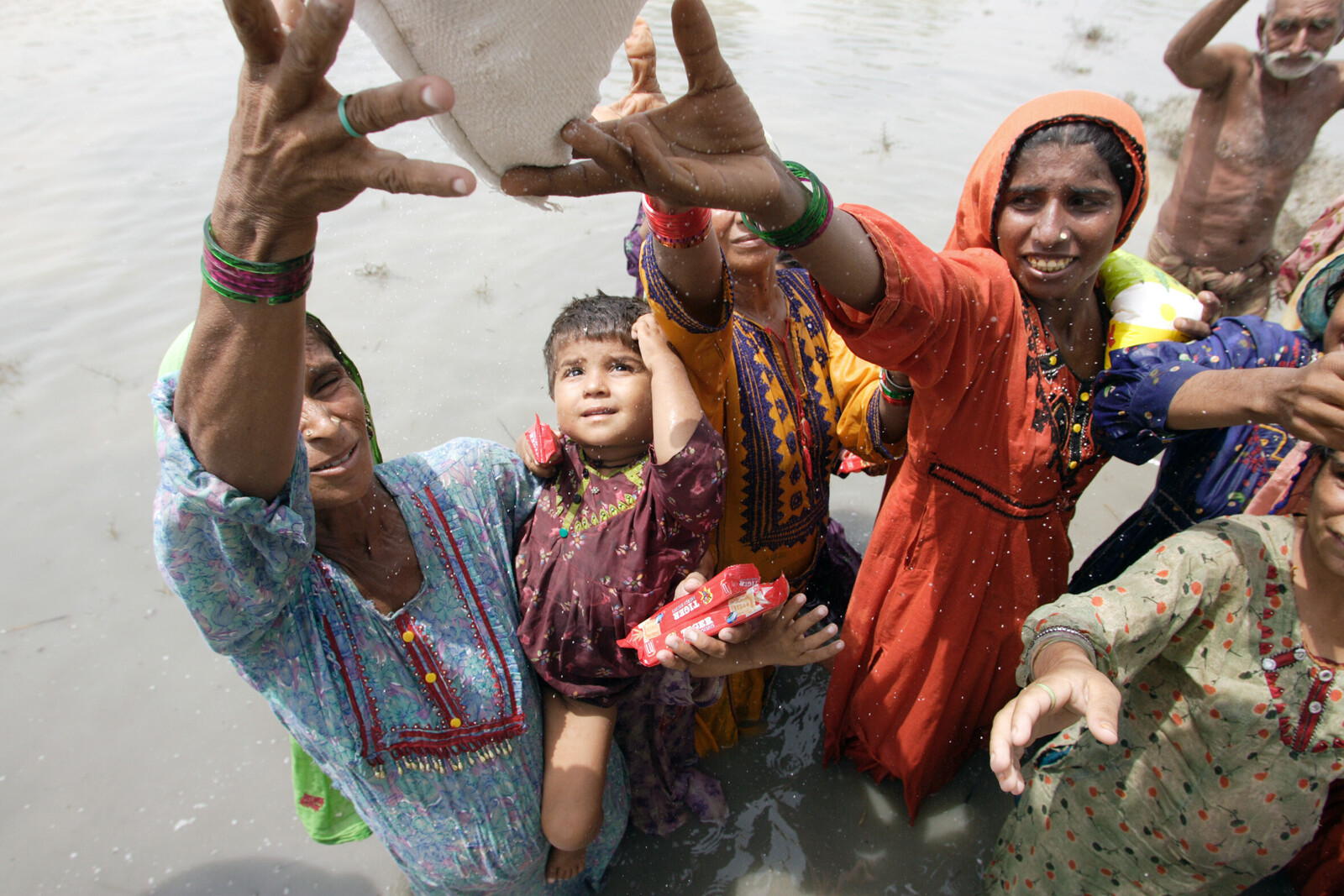 Frauen und Kinder erhalten nach der Flut in Pakistan Hilfsgüter