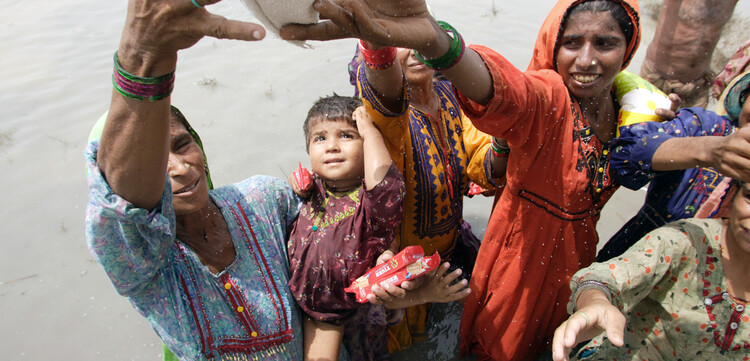 Frauen und Kinder erhalten nach der Flut in Pakistan Hilfsgüter