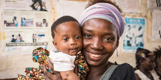 In Sierra Leone hält eine Frau in einer Hebammenschule ein Kind im Arm