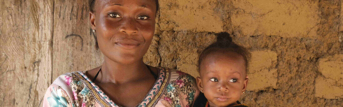 Eine Mutter aus Sierra Leone hält ihre kleine Tochter auf dem Arm