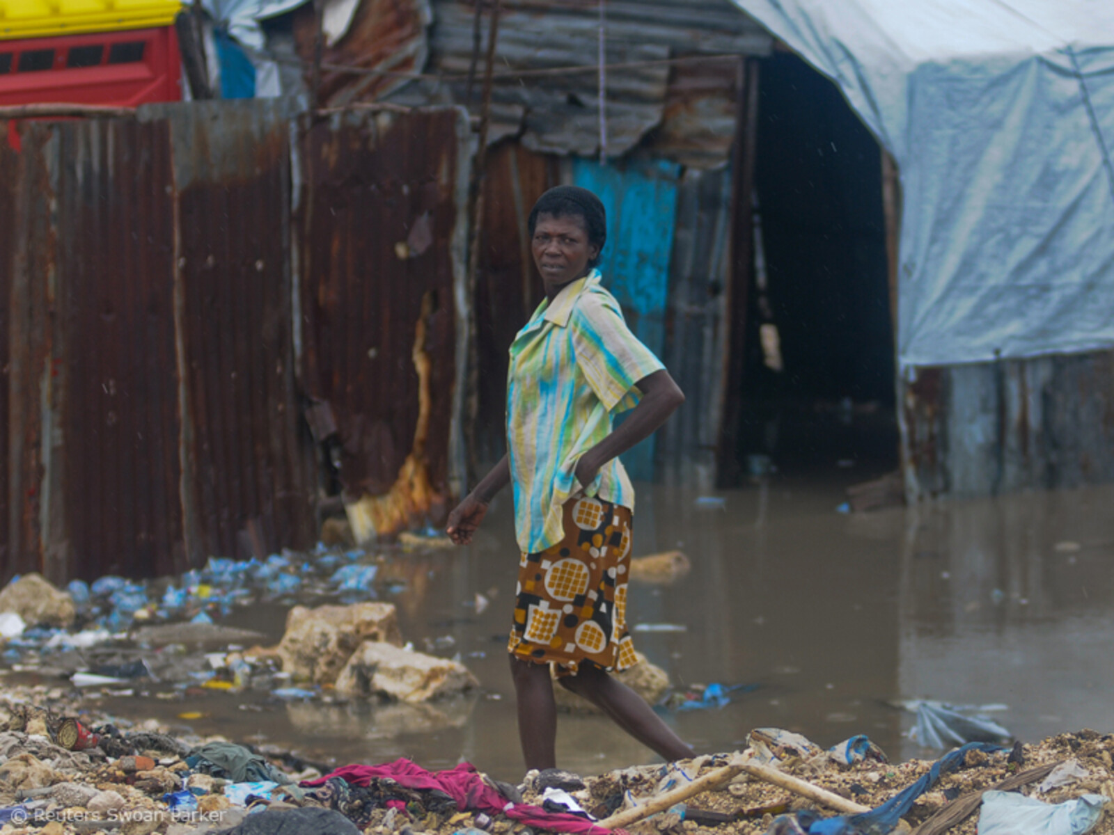 Haitianische Frau vor einer überschwemmten Notunterkunft in Port-au-Prince