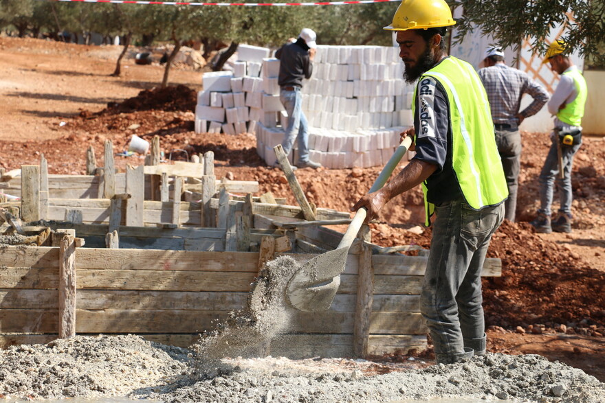 Ein Mann bei dem Bau einer Latrine in Syrien Ein Mann bei dem Bau einer Latrine in Syrien