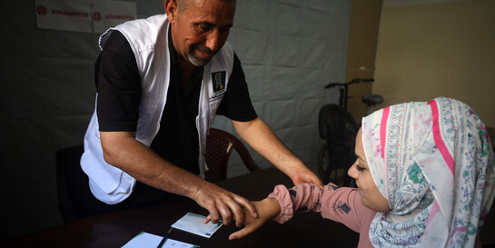 Ein Helfer leistet medizinische Nothilfe bei einer Frau Ein Helfer leistet medizinische Nothilfe bei einer Frau