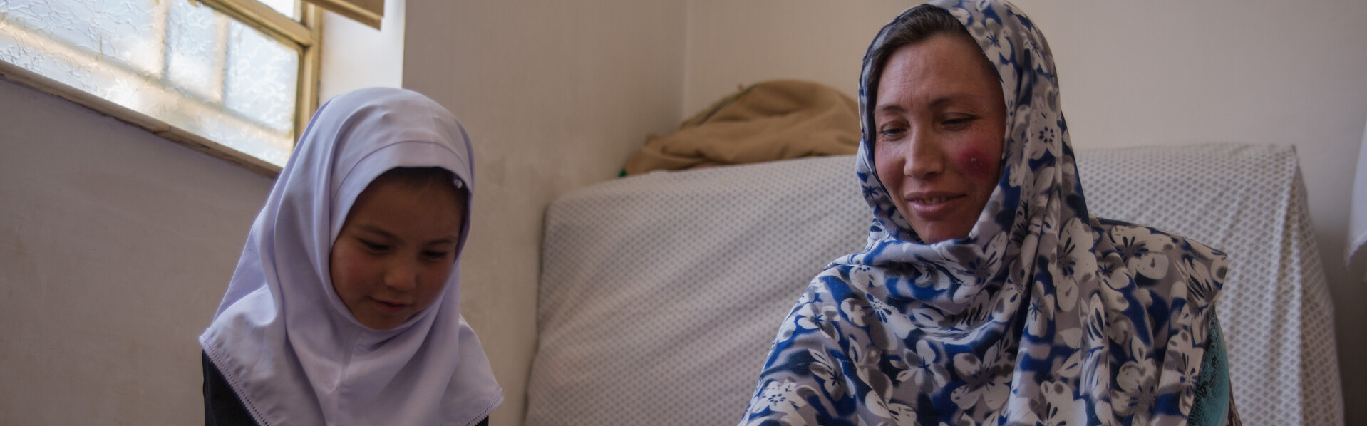 Bildung für Frauen in Afghanistan: Eine Mutter lernt mit ihrer Tochter das Lesen Bildung für Frauen in Afghanistan: Eine Mutter lernt mit ihrer Tochter das Lesen