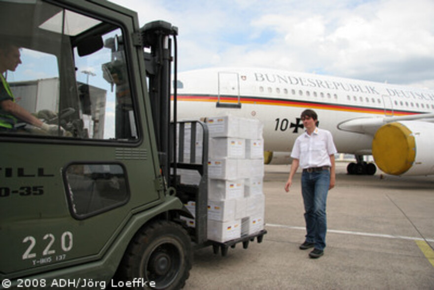 Zyklon in Birma: ADH Hilfsgüter werden zum Abtransport nach Birma verladen, rechts Carsten Stork ASB