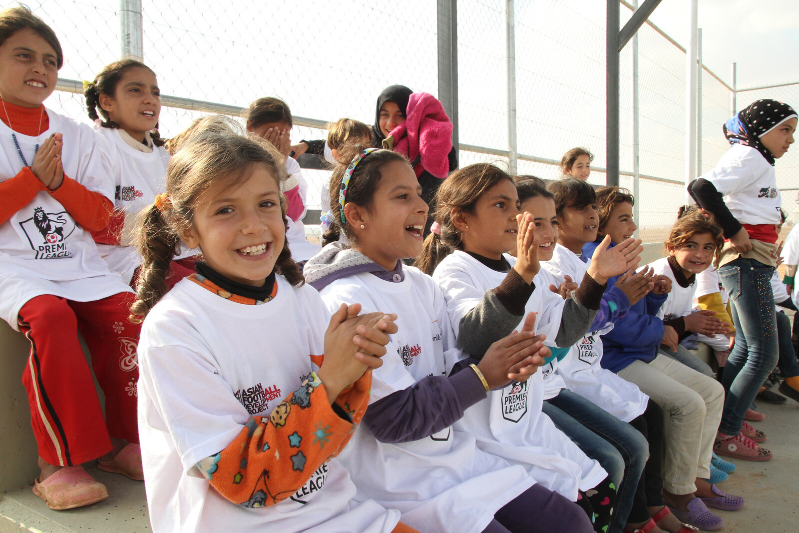 Kinder applaudieren auf einer Tribüne in einem Flüchtlingscamp Al Azraq.