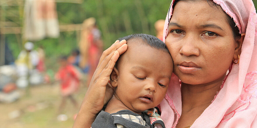Flucht vor dem Klima und der Verfolgung: Eine Rohingya mit ihrem Baby auf dem Arm Flucht vor dem Klima und der Verfolgung: Eine Rohingya mit ihrem Baby auf dem Arm