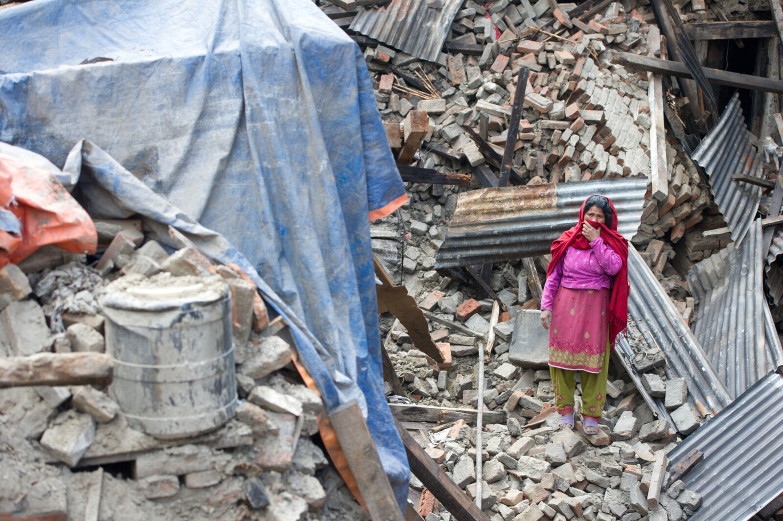 Nach dem Erdbeben in Nepal ist die Zerstörung groß. Eine Frau steht in den Trümmern ihres Hauses.